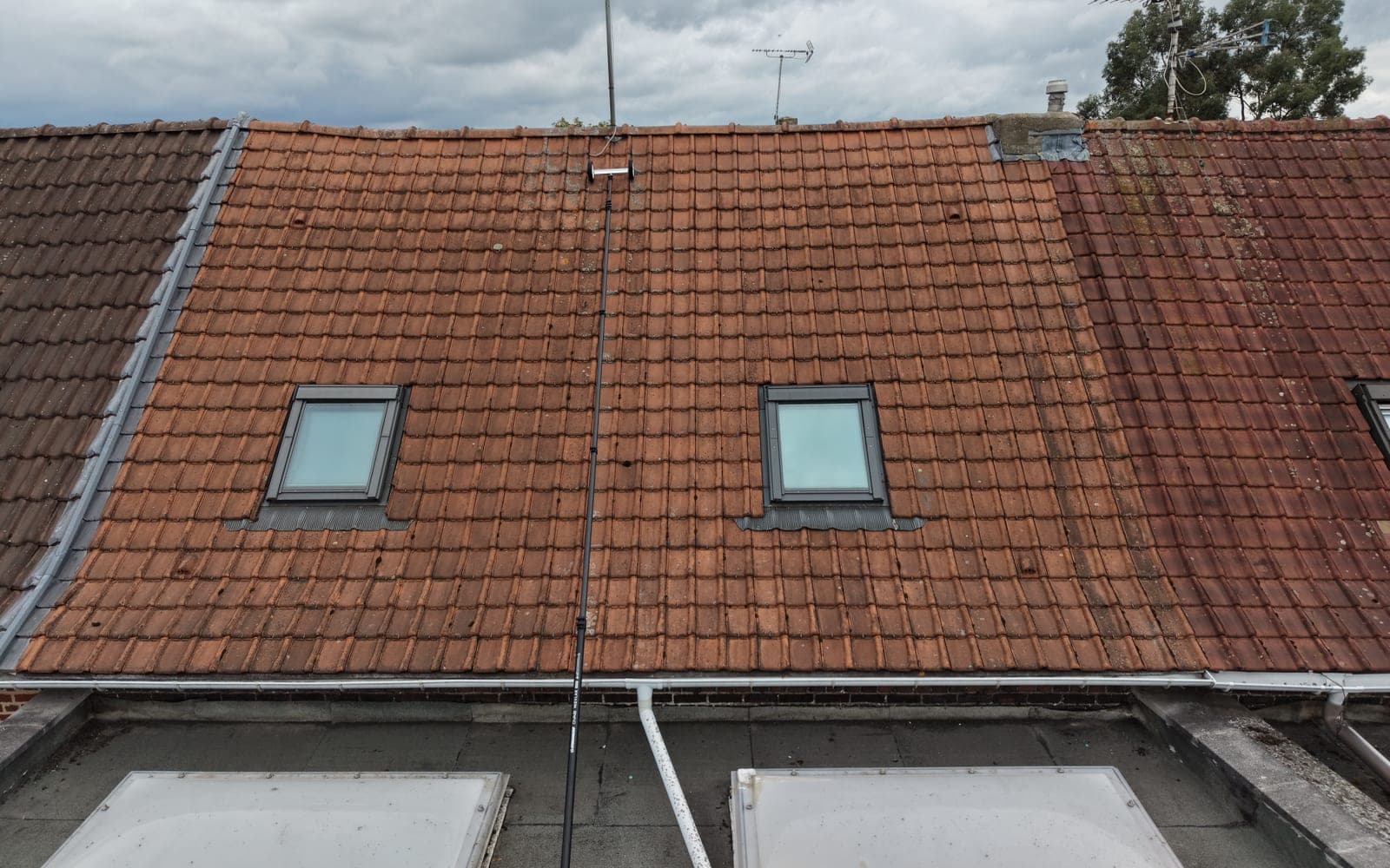 Toiture en tuiles nettoyée à la perche télescopique depuis le sol