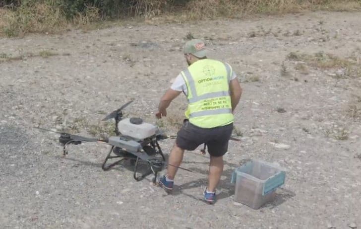Opérateur Option Drone Service préparant le drone agricole